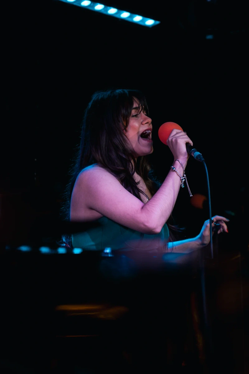 Vocalist performing under colourful stage lighting