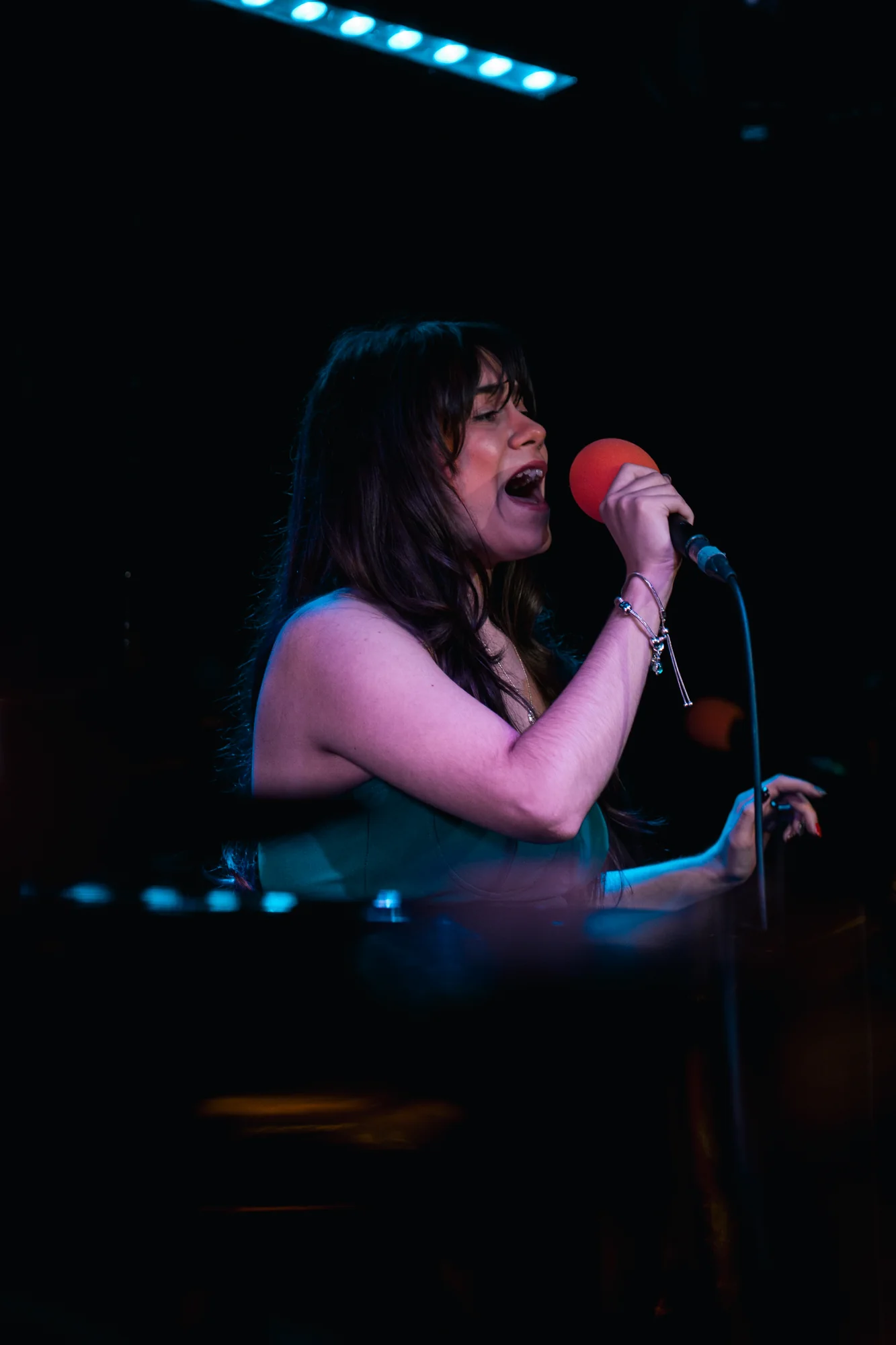 Vocalist performing under colourful stage lighting