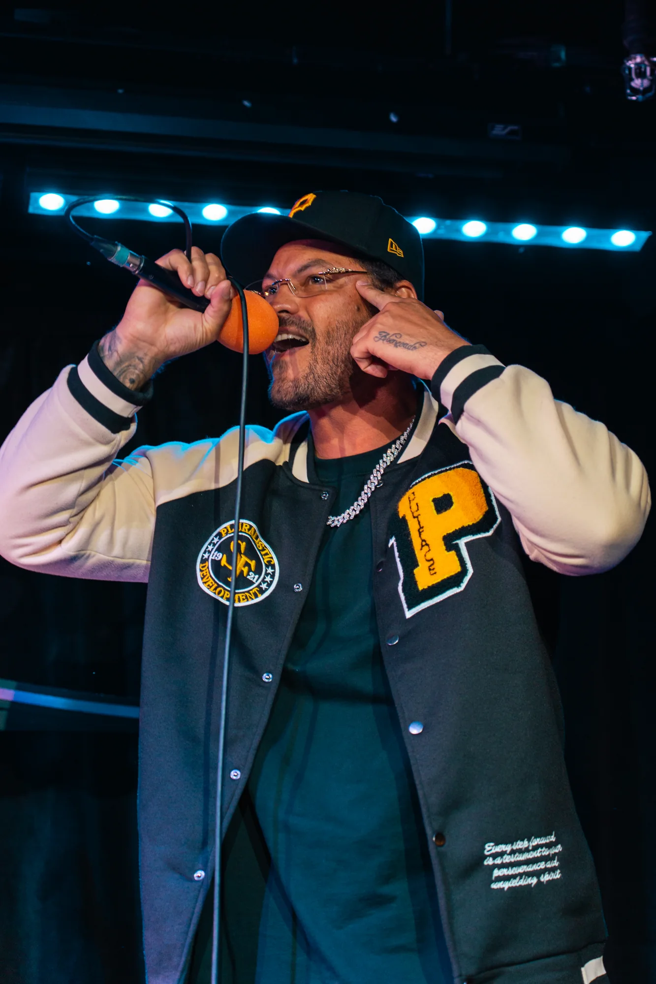 Male vocalist performing with an orange microphone