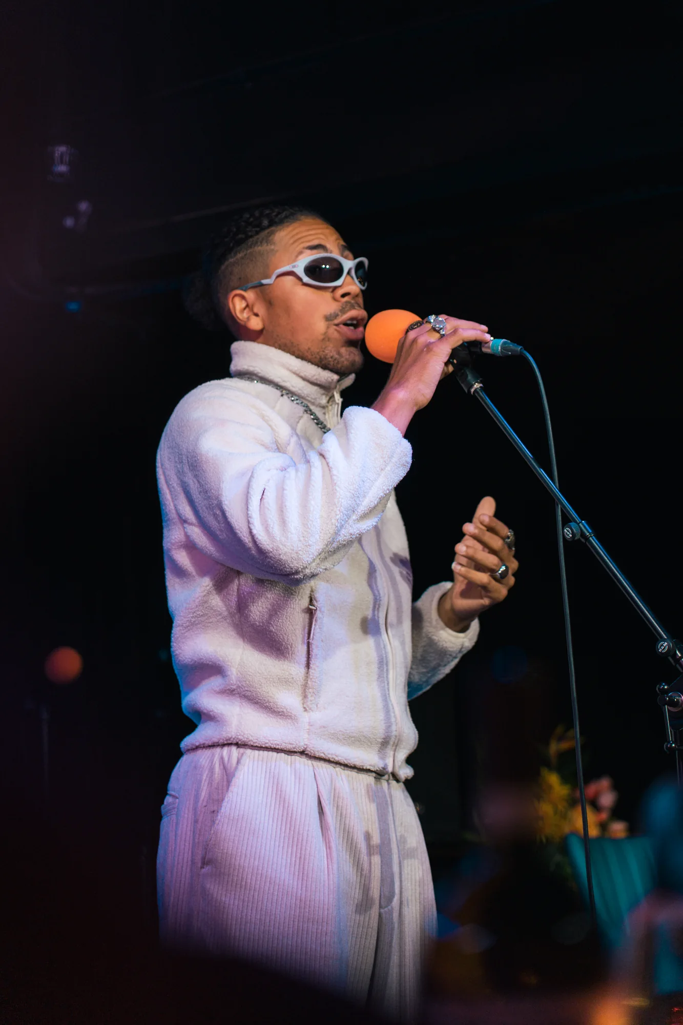 Singer performing in a white hoodie