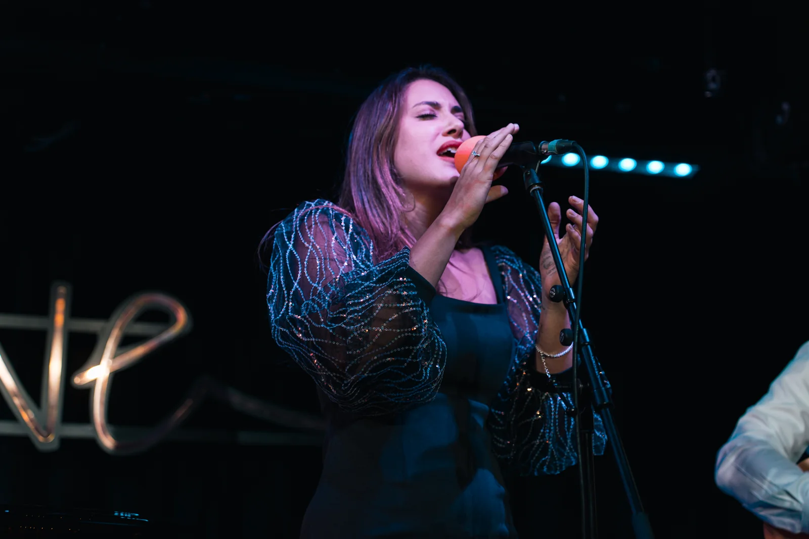 Female singer performing under blue stage lights
